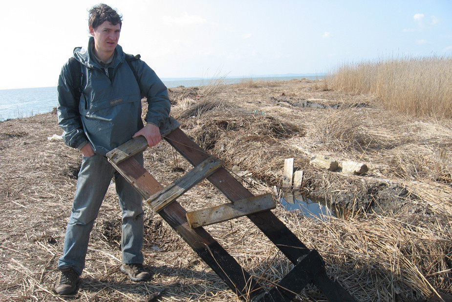 Дмитрий обследует берега после аварии танкера Волгонефть-139 в 2008 году. На деревянной конструкции — следы мазута