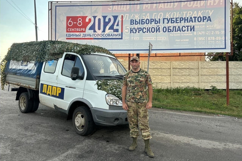 Алексей Томанов на фоне грузовика с помощью для российских военных