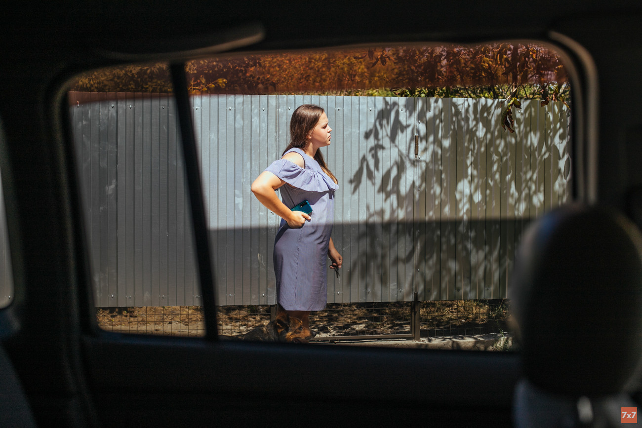 Люда у забора своего приюта. Пытается докричаться до собак, которых выпустила побегать и не может загнать обратно