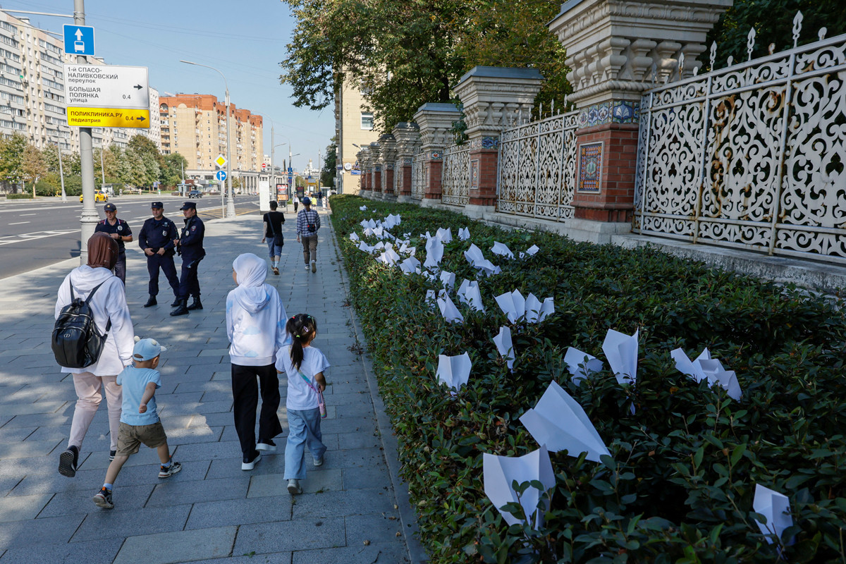 Люди проходят мимо бумажных самолетиков — символа мессенджера Telegram, оставленных во время акции в поддержку свободы слова у посольства Франции, Москва, 25 августа 2024 года.