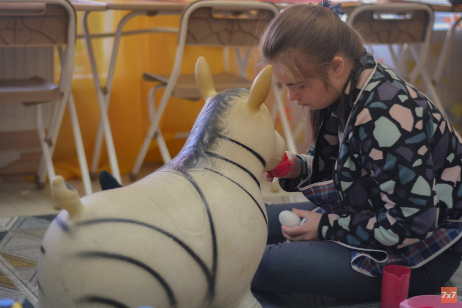 Даша играет с резиновой зеброй в перерыве между занятиями