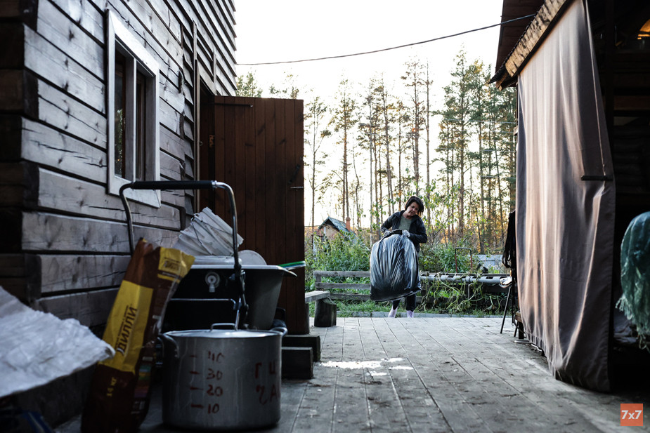 Волонтер Варвара несет мешки с соломой, которую будет стелить в будках у собак Ирины
