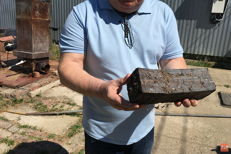 Дмитрий Алифиренко показывает брикет из отходов