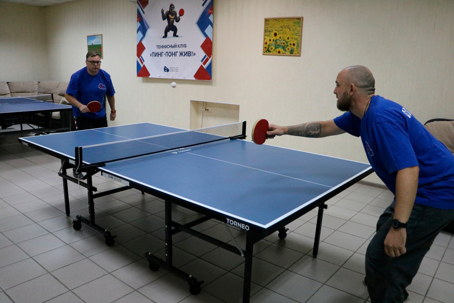Участник проекта «Герои НовоСибири» на тренировке с командой минтруда и соцразвития по настольному теннису, сентябрь 2025 года. Фото: министерство труда и социального развития НСО / VK