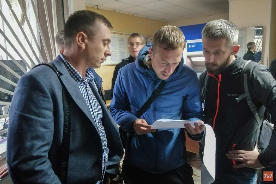 Освобожденный кандидат Андрей Цесарев (в пиджаке) читает протокол